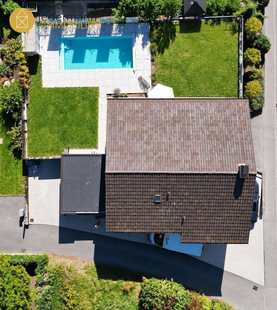 Luftaufnahme des Hauses mit Garten, Pool und gepflegter Rasenfläche.