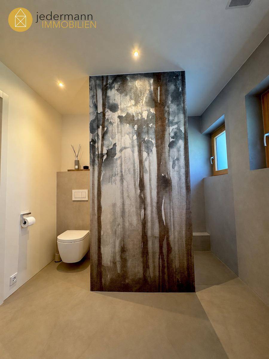 Modernes Badezimmer mit Wand-WC und dekorativer Wandgestaltung.