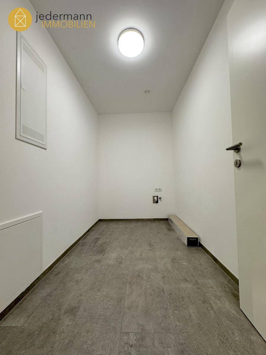 Praktischer Hauswirtschaftsraum mit Fliesenboden und Anschlüssen.