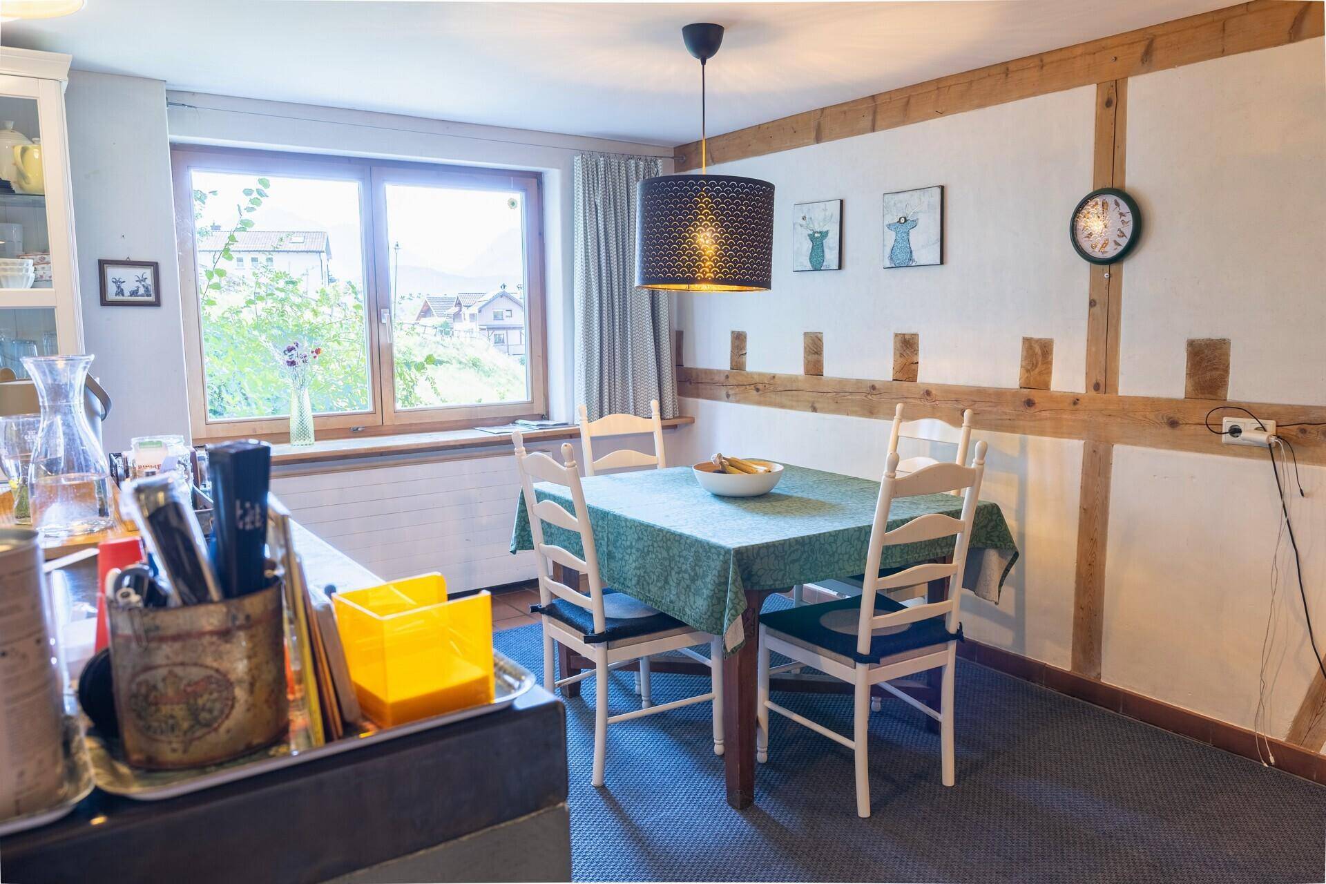 Gemütlicher Essbereich mit Holzbalken, Fenster und einem Esstisch für gesellige Mahlzeiten.