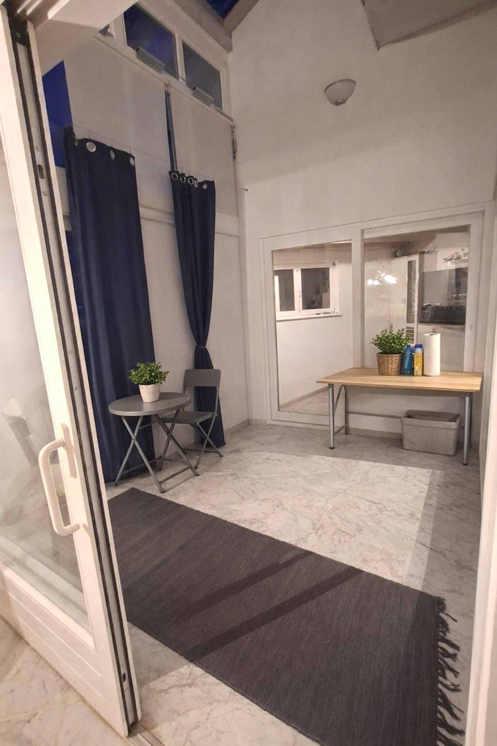 Heller Wintergarten mit Glasdach, kleinem Tisch und Stühlen, ideal für entspannte Stunden.