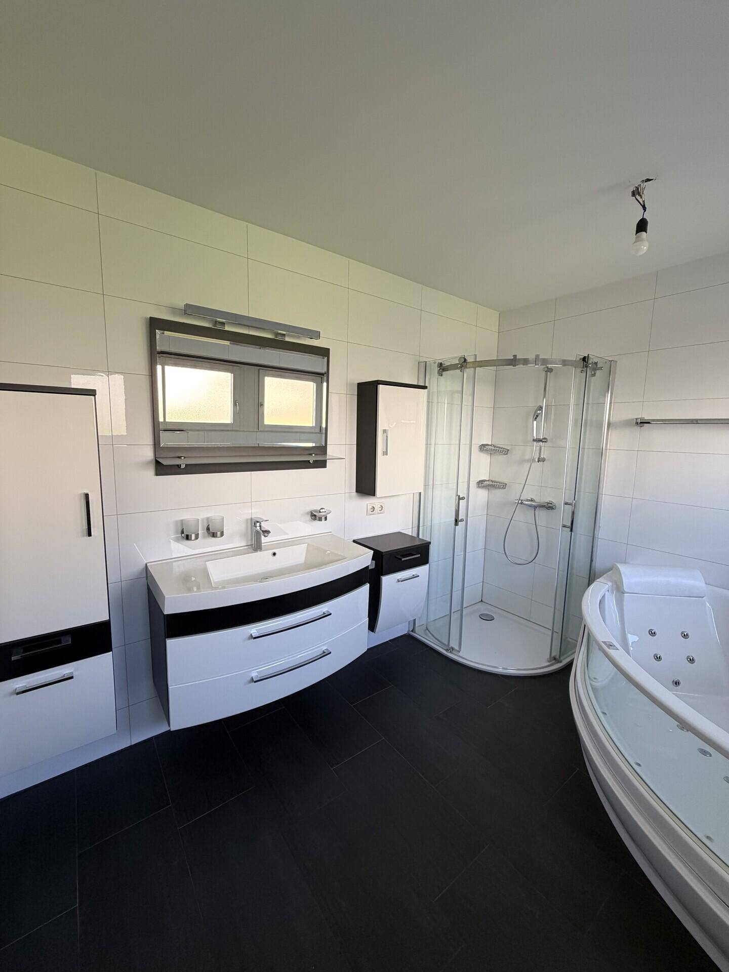 Modernes Badezimmer mit Duschkabine, Whirlpool-Badewanne und Doppelwaschbecken.