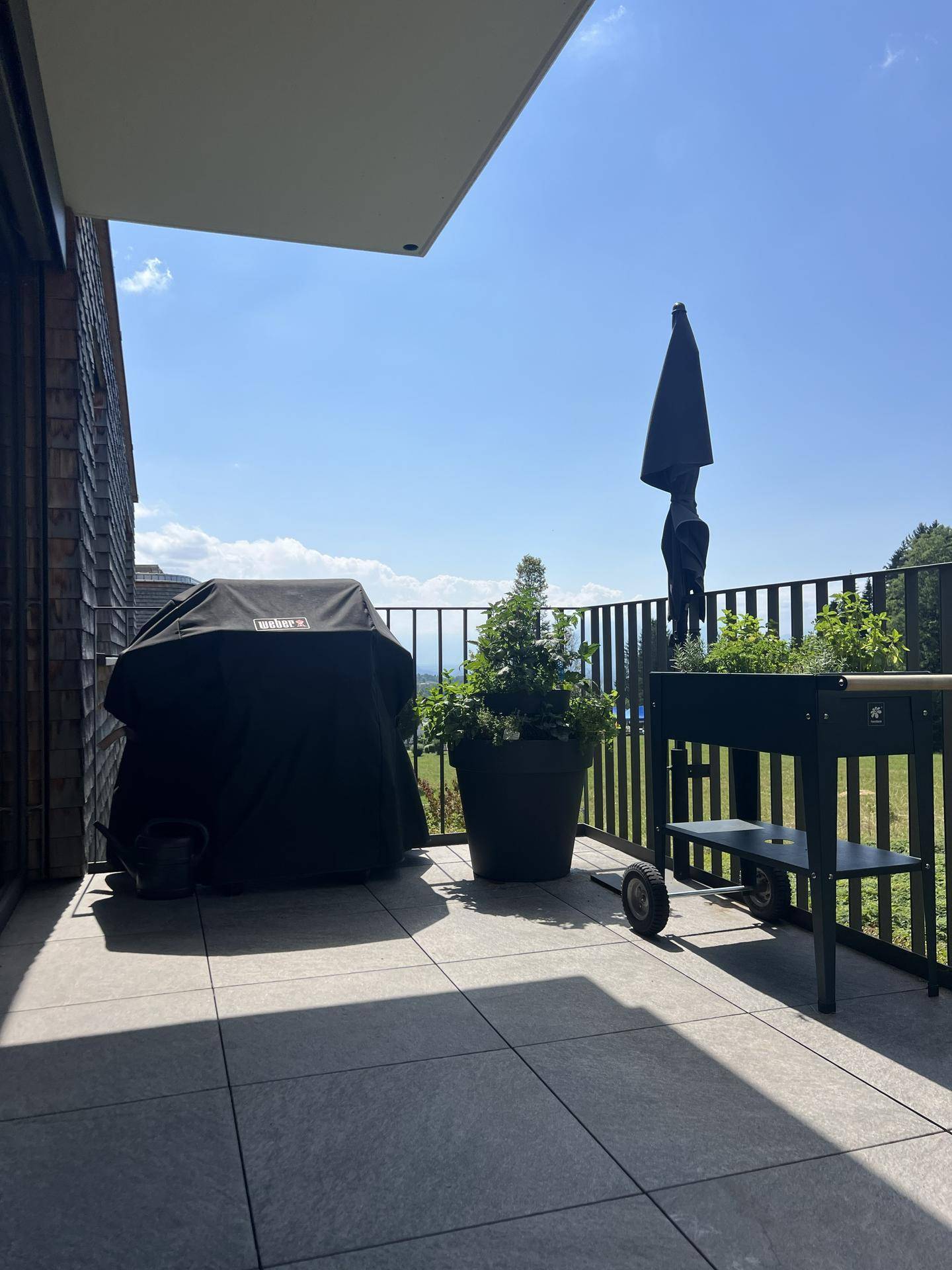 Sonniger Balkon mit Grillplatz und weitem Blick ins Grüne, ideal für entspannte Stunden.