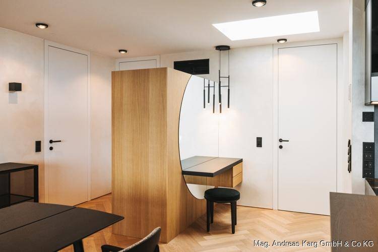 Heller Flur mit modernem Design, großem runden Spiegel, Holzelementen und Oberlicht.