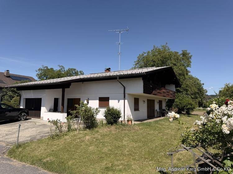 Traditionelles Einfamilienhaus mit Garage, Vorgarten und gepflasterter Einfahrt.