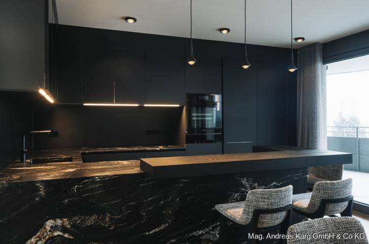 Elegante schwarze Küche mit Marmorarbeitsplatte, integrierten Geräten und stilvoller Beleuchtung.