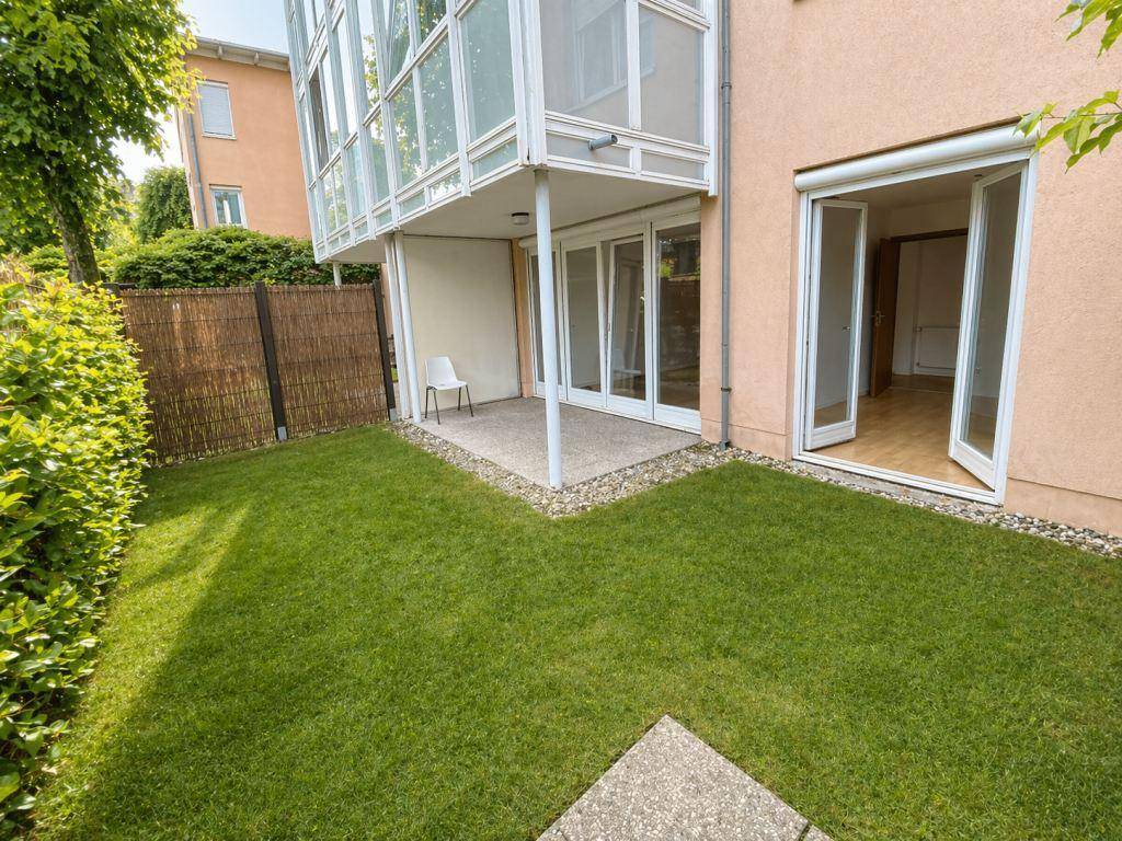 Kleiner privater Gartenbereich mit Rasenfläche und direktem Zugang zur überdachten Terrasse.