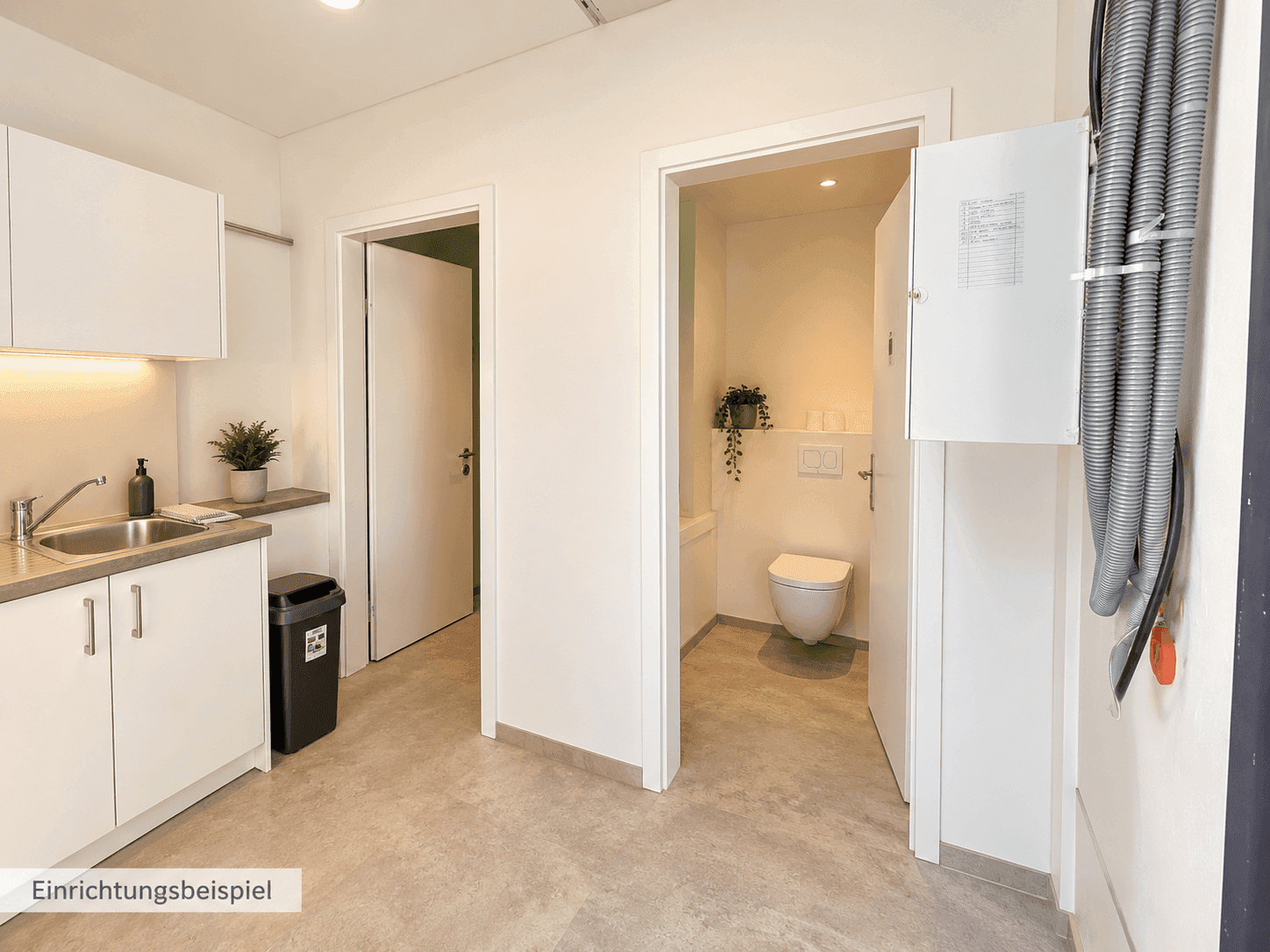 Funktionaler Hauswirtschaftsraum mit kleiner Teeküche und angrenzender, moderner Toilette.