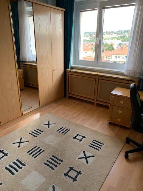 Helles Zimmer mit großem Kleiderschrank und Fensterblick ins Grüne.