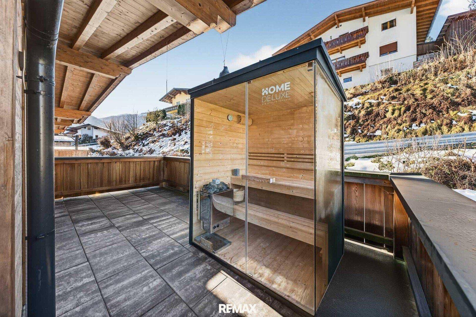 Außensauna auf einer gefliesten Terrasse mit Blick auf die umliegende Landschaft.