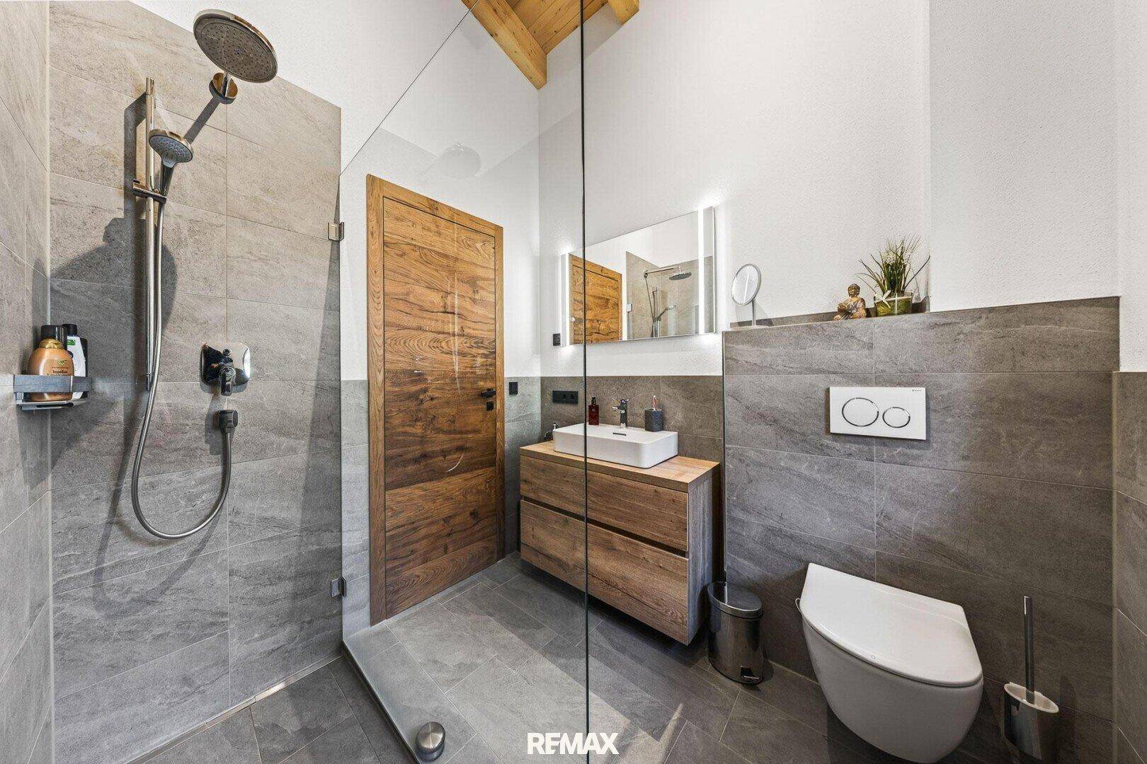 Modernes Badezimmer mit begehbarer Dusche, Wand-WC und Holzwaschtisch.