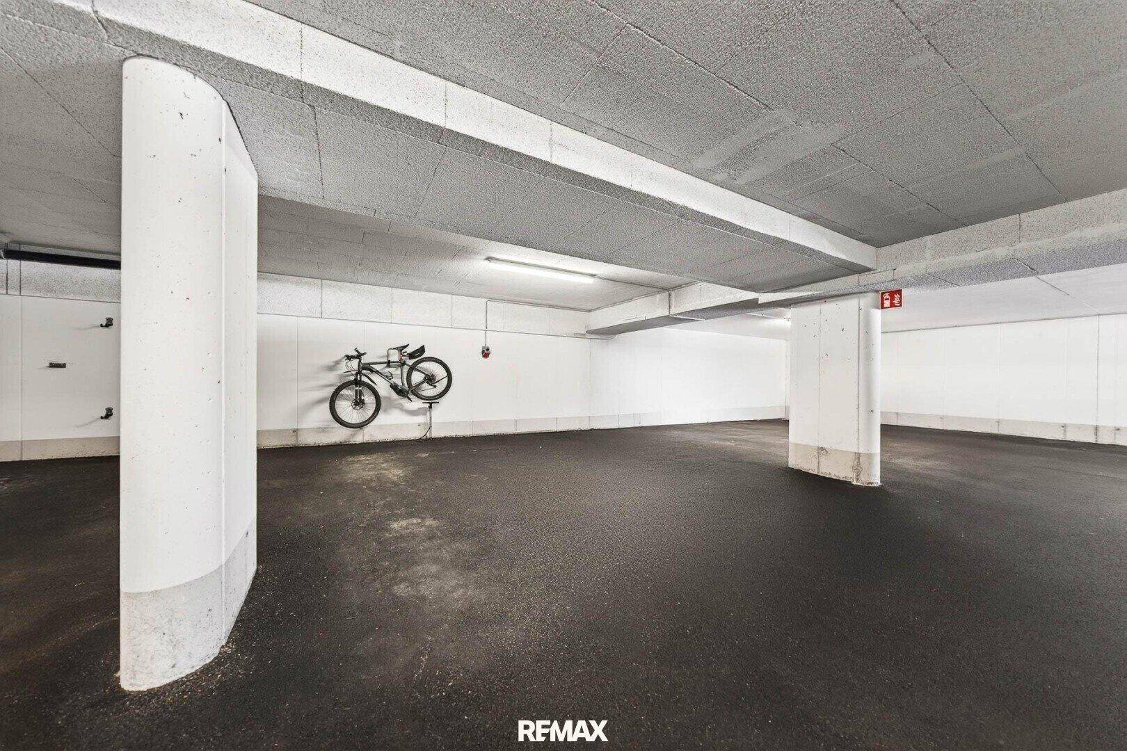 Geräumige Tiefgarage mit Betonstützen und Fahrradabstellmöglichkeit.