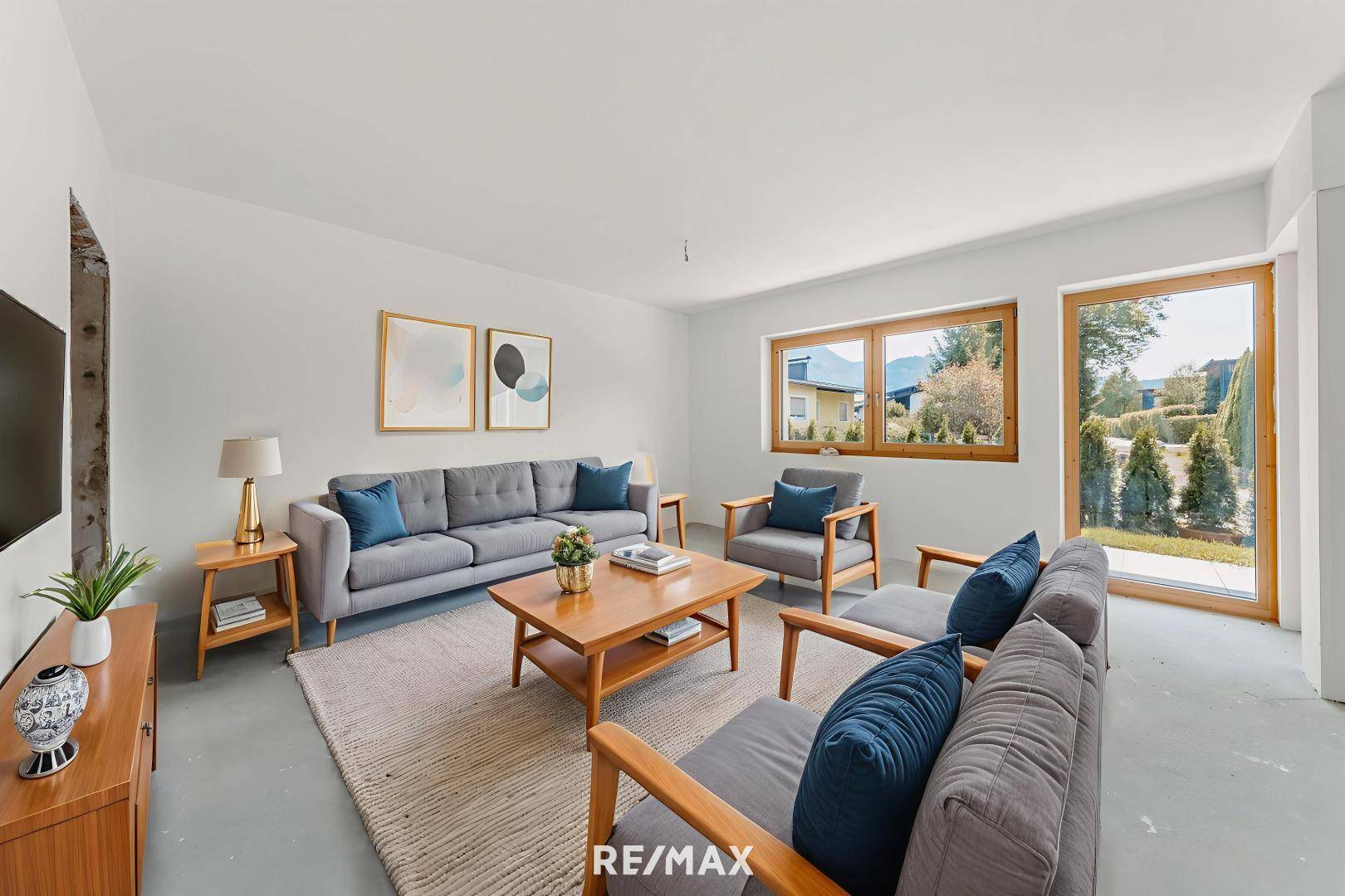 Gemütliches Wohnzimmer mit modernen Möbeln, Teppich und großen Fenstern zum Garten.