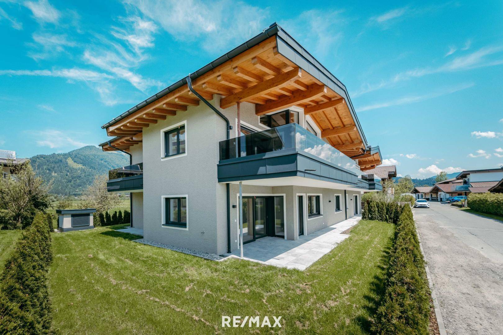 Moderne Architektur des Gebäudes mit Balkonen, großen Fenstern und Bergblick.