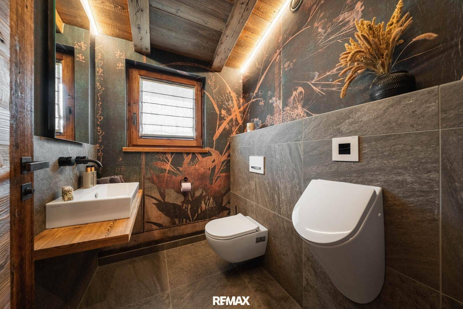 Modernes Gäste-WC mit Urinal, Waschbecken und dekorativer Wandgestaltung.