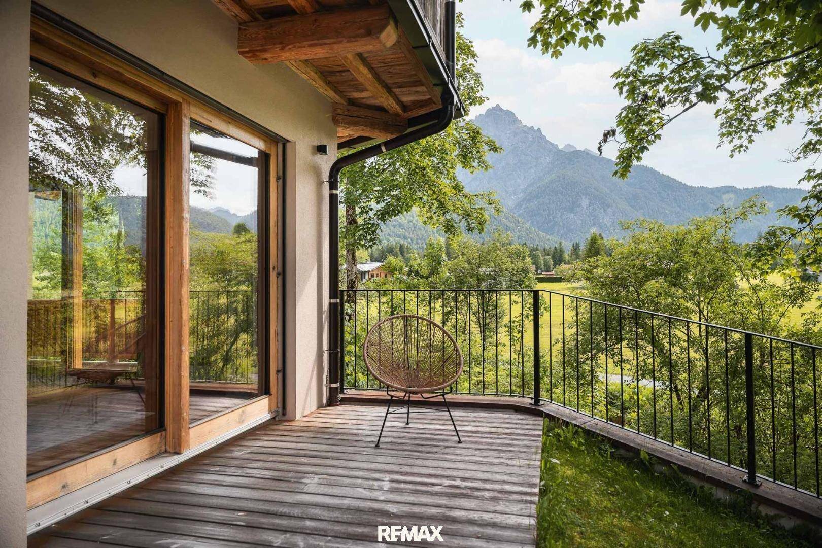 Balkon mit Holzboden, Metallgeländer und atemberaubendem Bergblick.