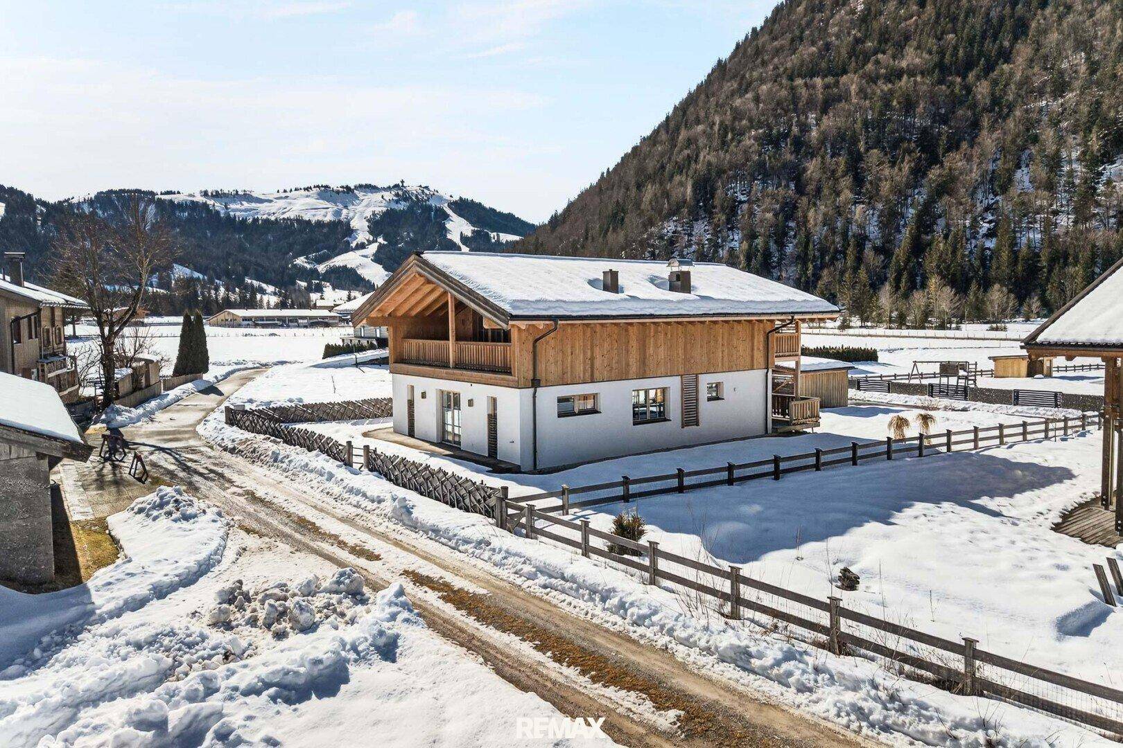 Attraktives Holzhaus in verschneiter Alpenlandschaft mit Bergblick und sonniger Lage.