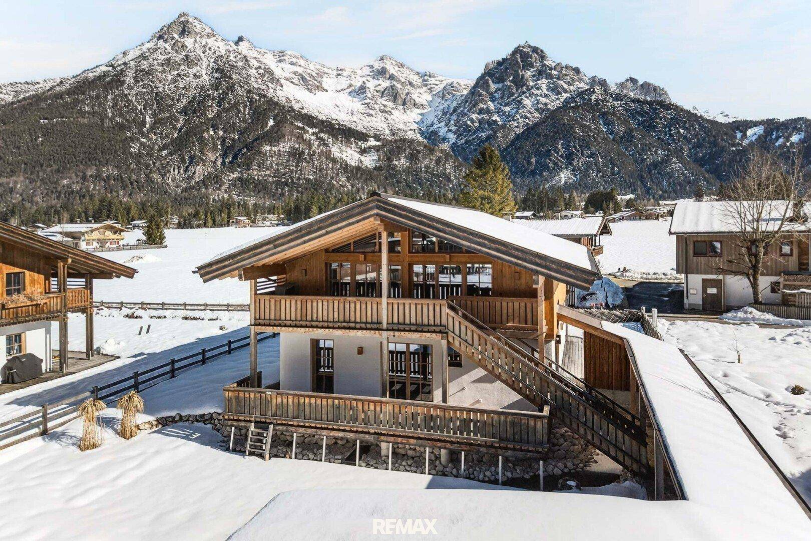Charmantes Chalet in verschneiter Berglandschaft mit traditioneller Holzarchitektur.