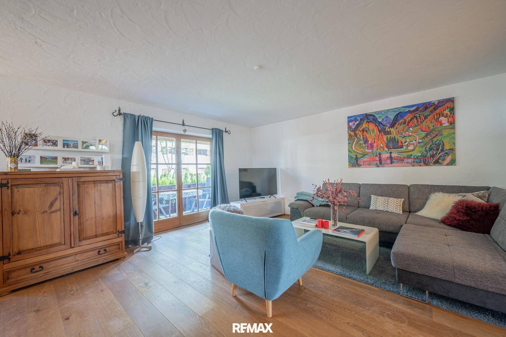 Heller Wohn-Essbereich mit Holzboden, traditionellem Schrank und Zugang zum Balkon.