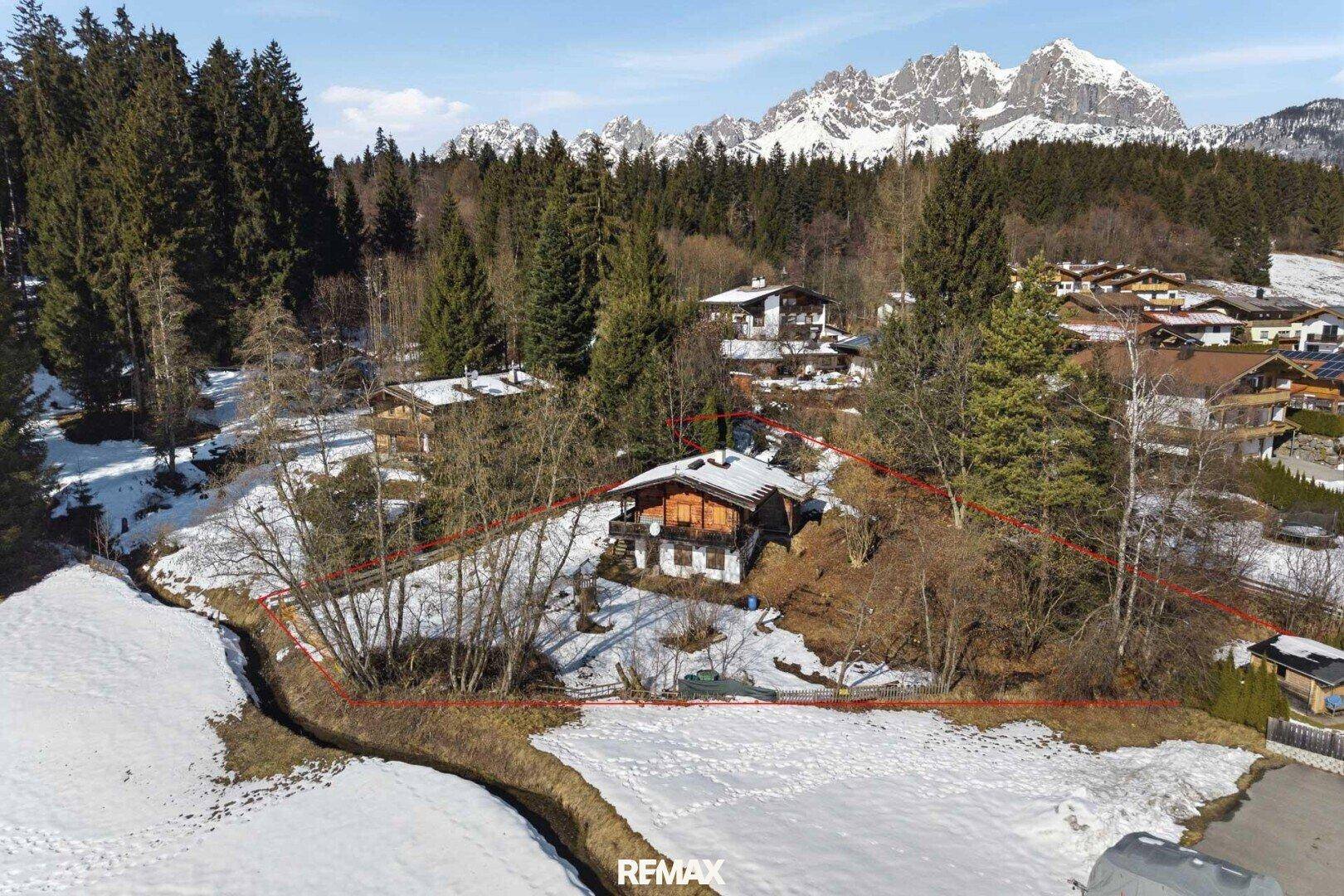 Luftaufnahme des Anwesens in einer verschneiten Landschaft mit umliegenden Wäldern und majestätischem Bergblick.