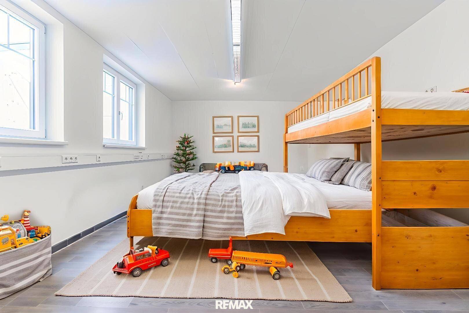 Geräumiges Kinderzimmer mit Etagenbett, Einzelbett und Fliesenboden, ideal für Geschwister.