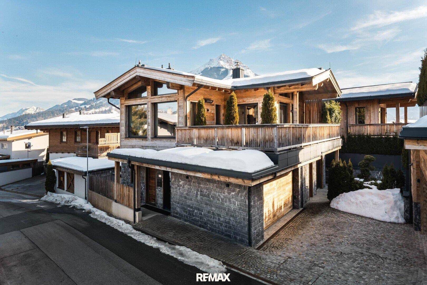 Luxuriöses Chalet im alpinen Stil mit Holzelementen, Steinfassade und schneebedeckter Umgebung.
