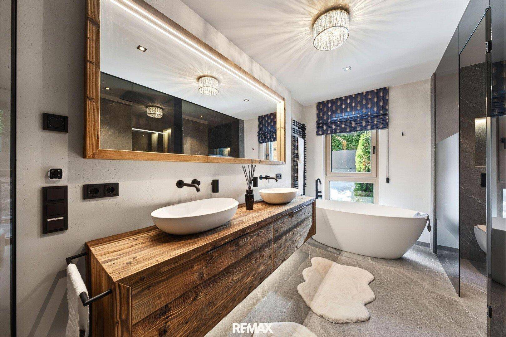 Modernes Badezimmer mit freistehender Badewanne, Doppelwaschbecken und Holzwaschtisch.