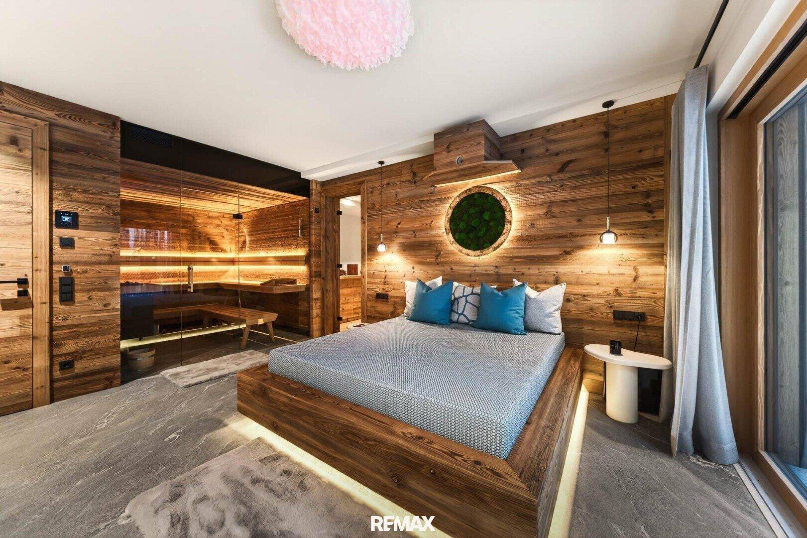 Luxuriöses Schlafzimmer mit integrierter Sauna, Holzbett und stilvoller Beleuchtung.