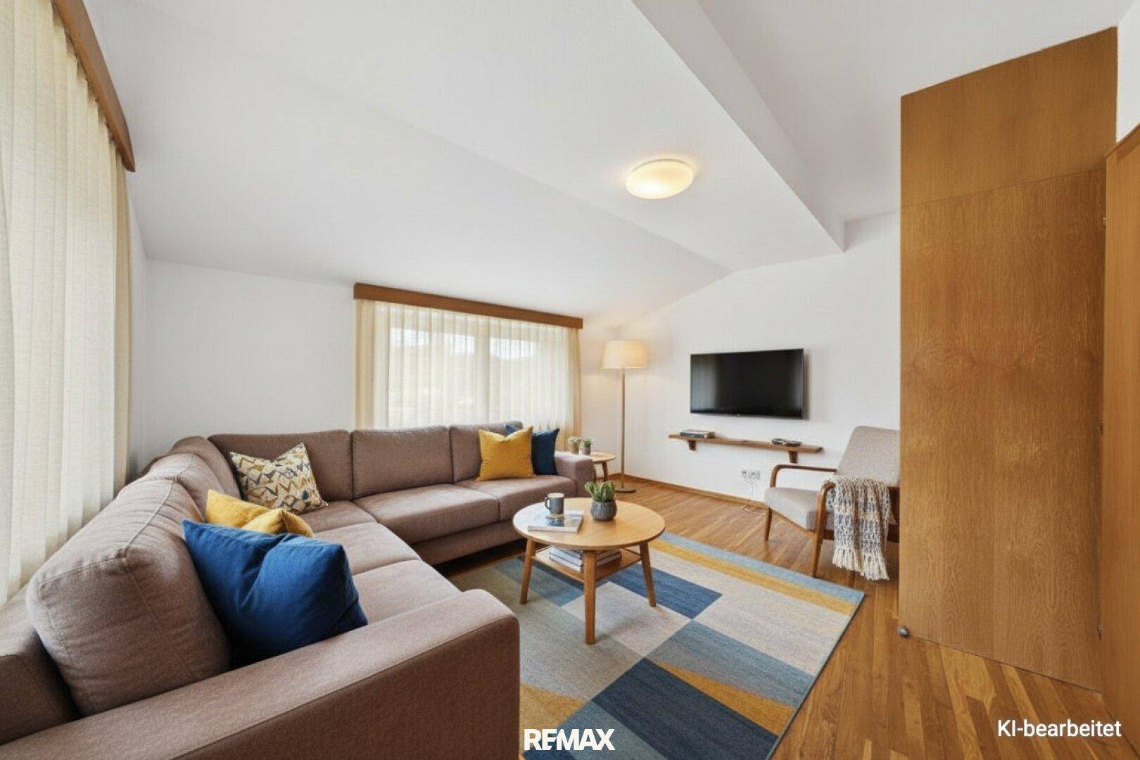 Modernes Wohnzimmer mit großem Ecksofa, Holzboden und schrägen Decken.