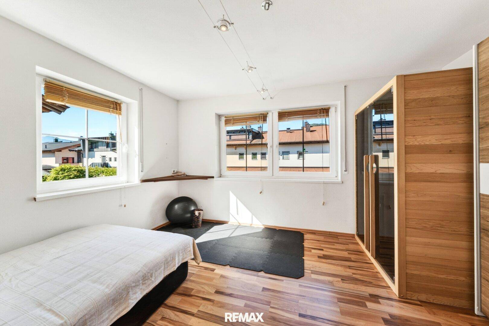 Helles Zimmer mit integrierter Sauna, Holzboden und Blick auf die umliegende Wohngegend.
