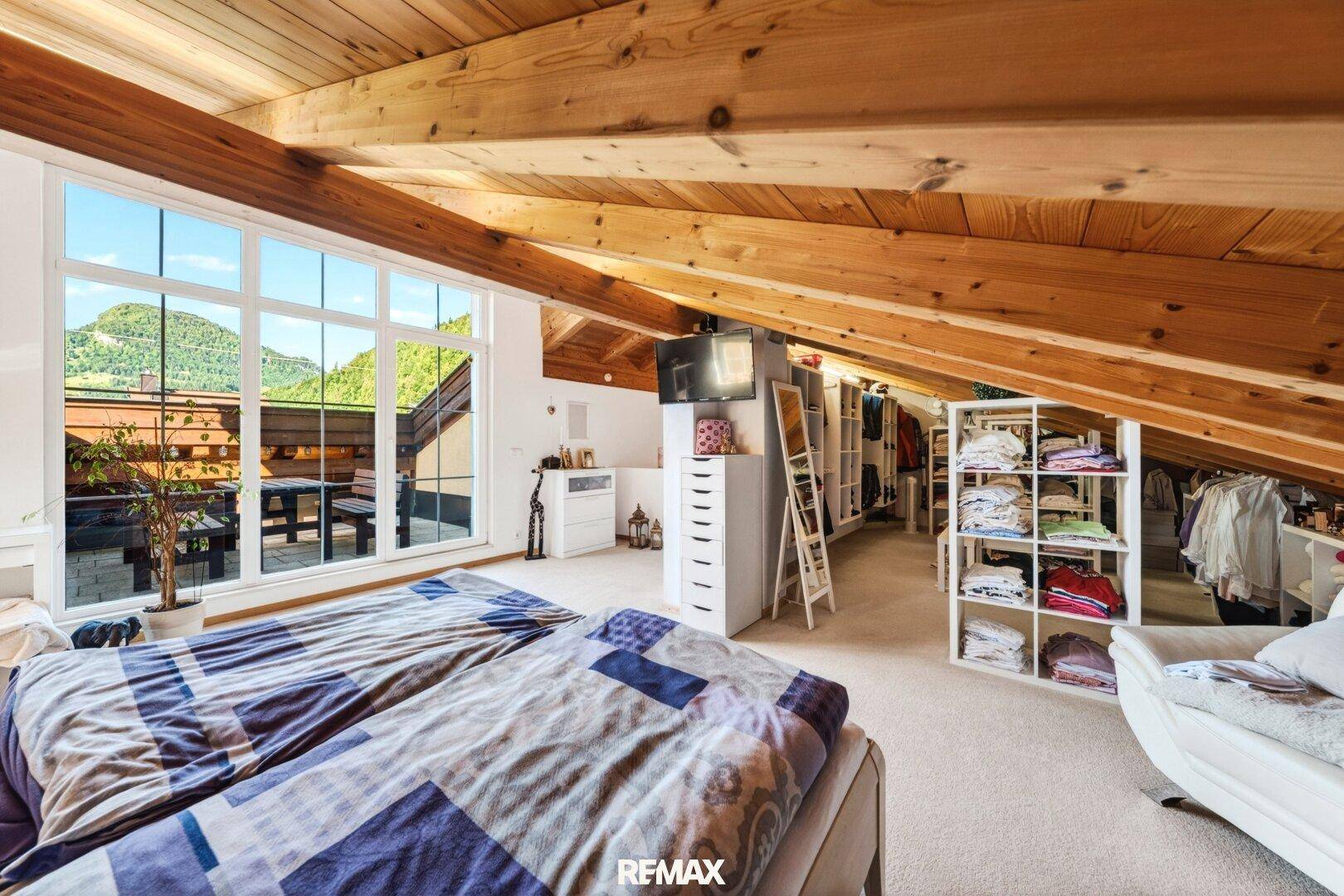 Geräumiges Schlafzimmer im Dachgeschoss mit Bergblick und Kleiderschränken.