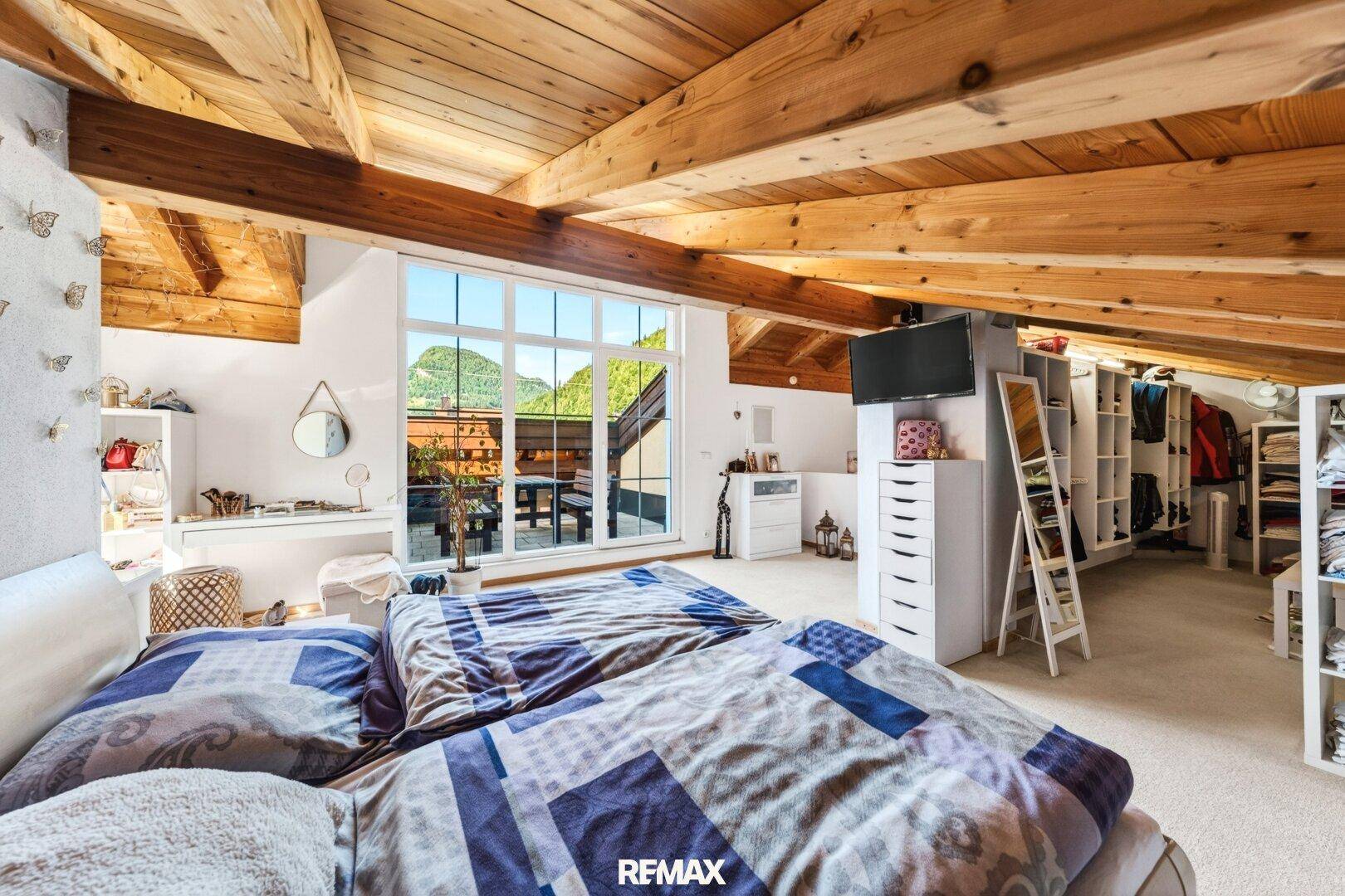Helles Dachgeschoss-Schlafzimmer mit Bergblick und integriertem Ankleidebereich.