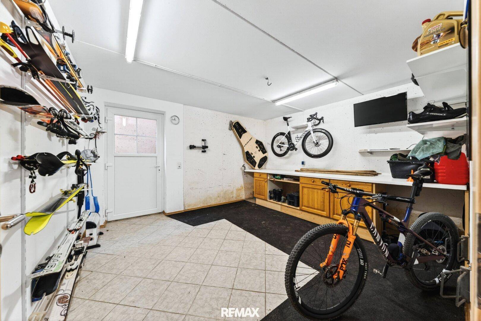 Geräumige Garage mit Abstellmöglichkeiten für Fahrräder und Skiausrüstung.