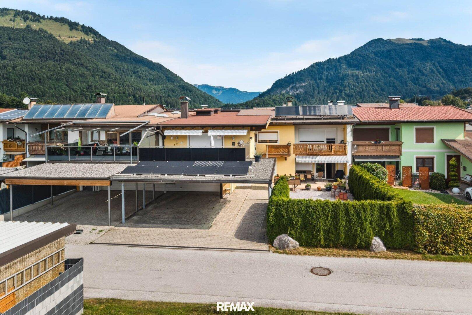 Luftaufnahme des Hauses mit umliegenden Gebäuden und der Berglandschaft im Hintergrund.