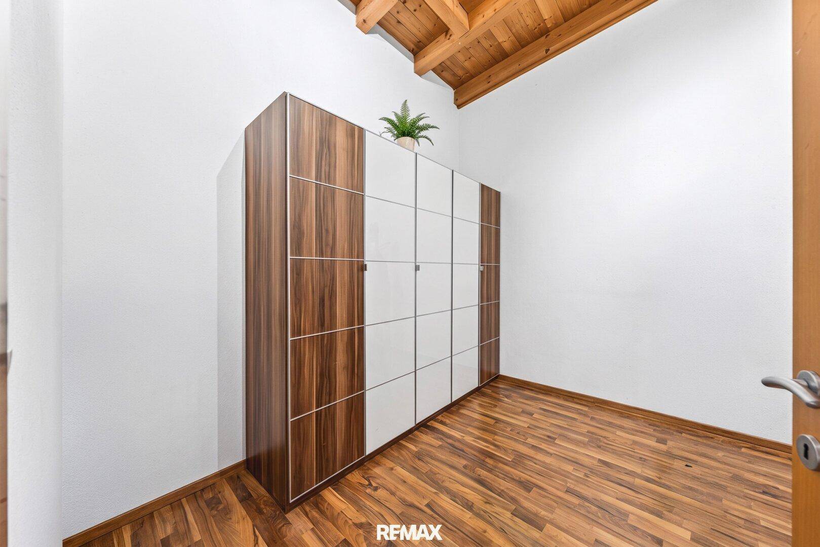 Heller Raum mit modernem Kleiderschrank und Holzboden.