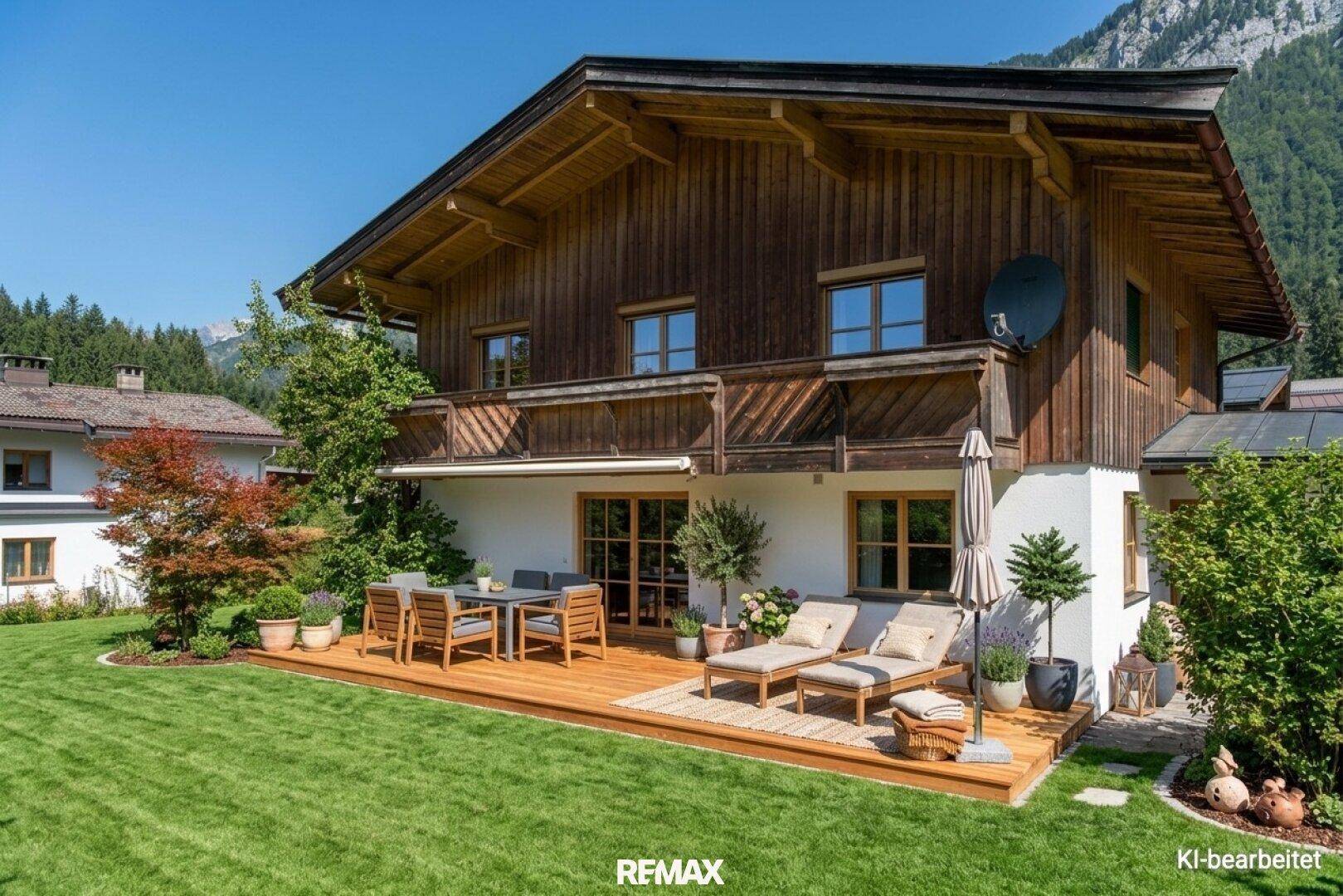 Große Holzterrasse mit Essbereich und Liegestühlen, umgeben von einem gepflegten Garten.