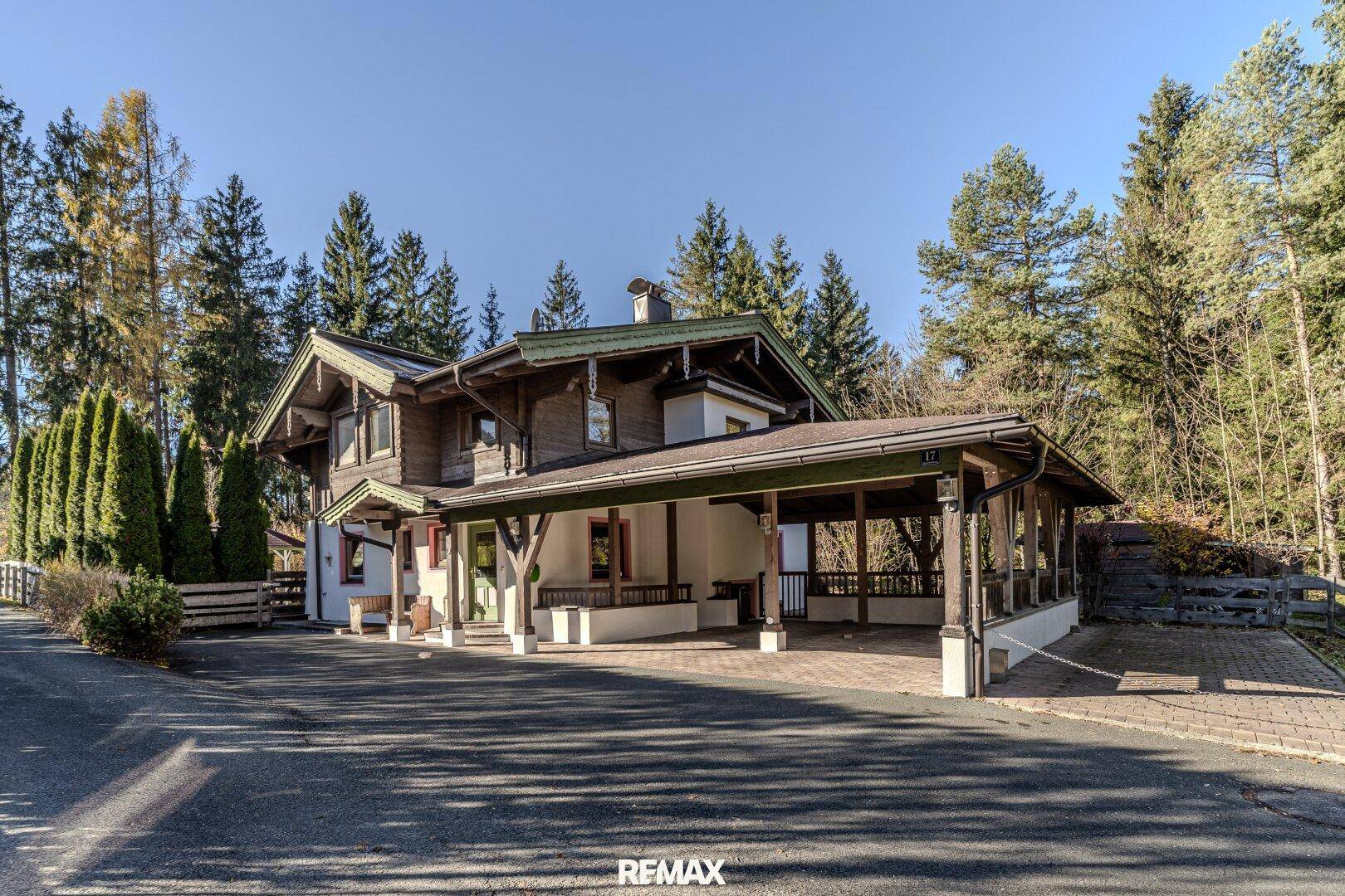 Attraktive Hausfassade mit großem Carport und traditionellen Holzelementen.