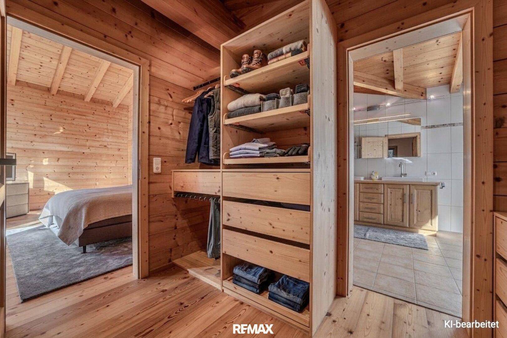 Praktischer begehbarer Kleiderschrank mit Holzregalen, der Schlafzimmer und Bad verbindet.