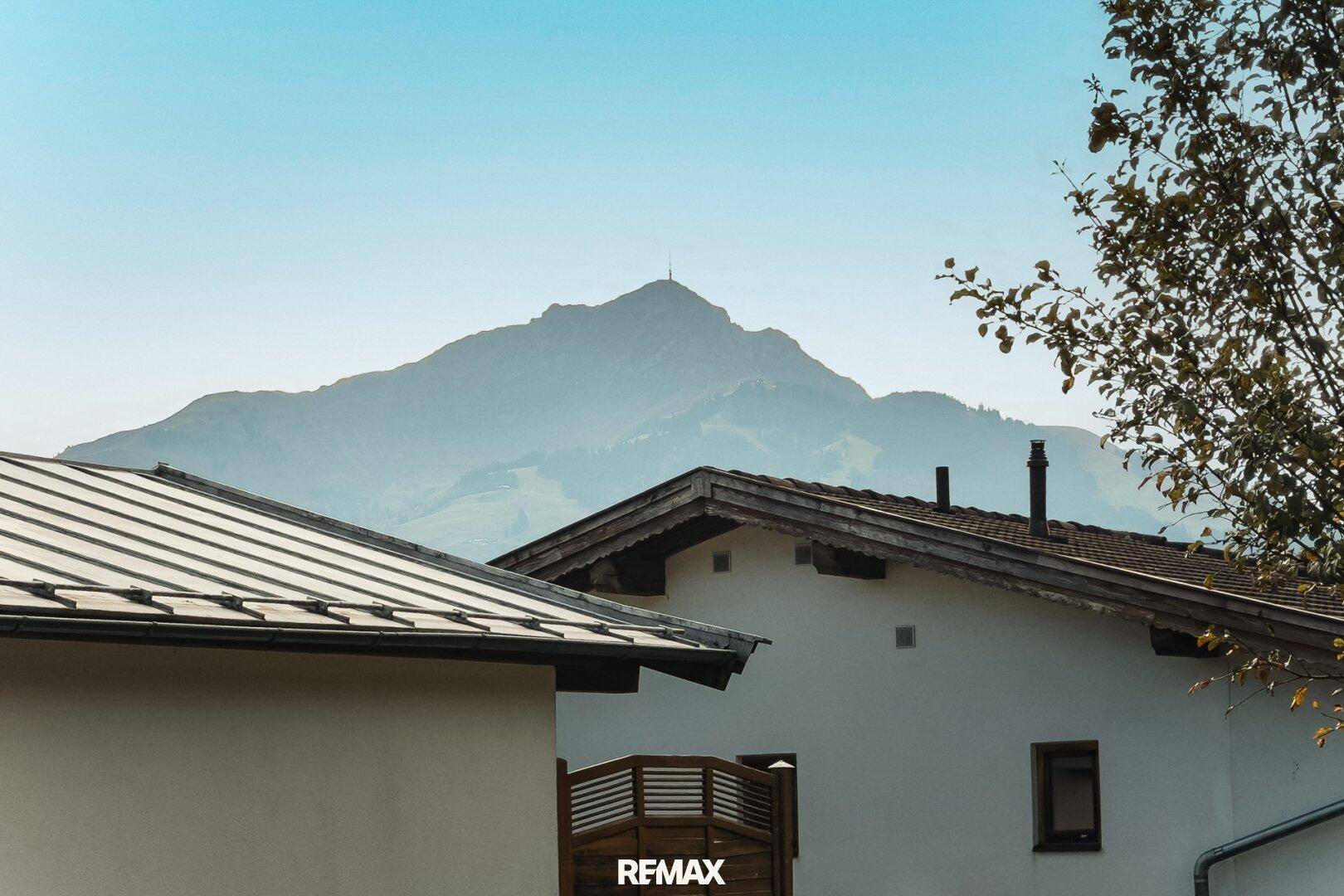 Malerischer Bergblick über traditionelle Hausdächer in ländlicher Umgebung.