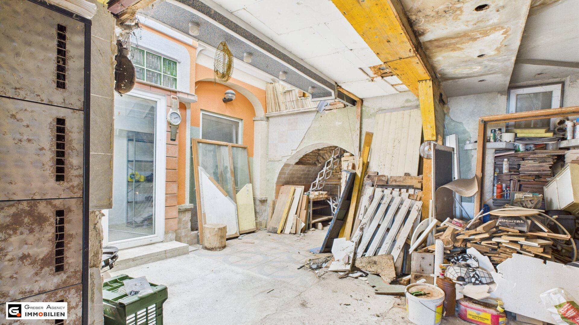 Innenraum im Umbau mit Baumaterialien und sichtbaren Bauelementen, die Renovierungsbedarf zeigen.