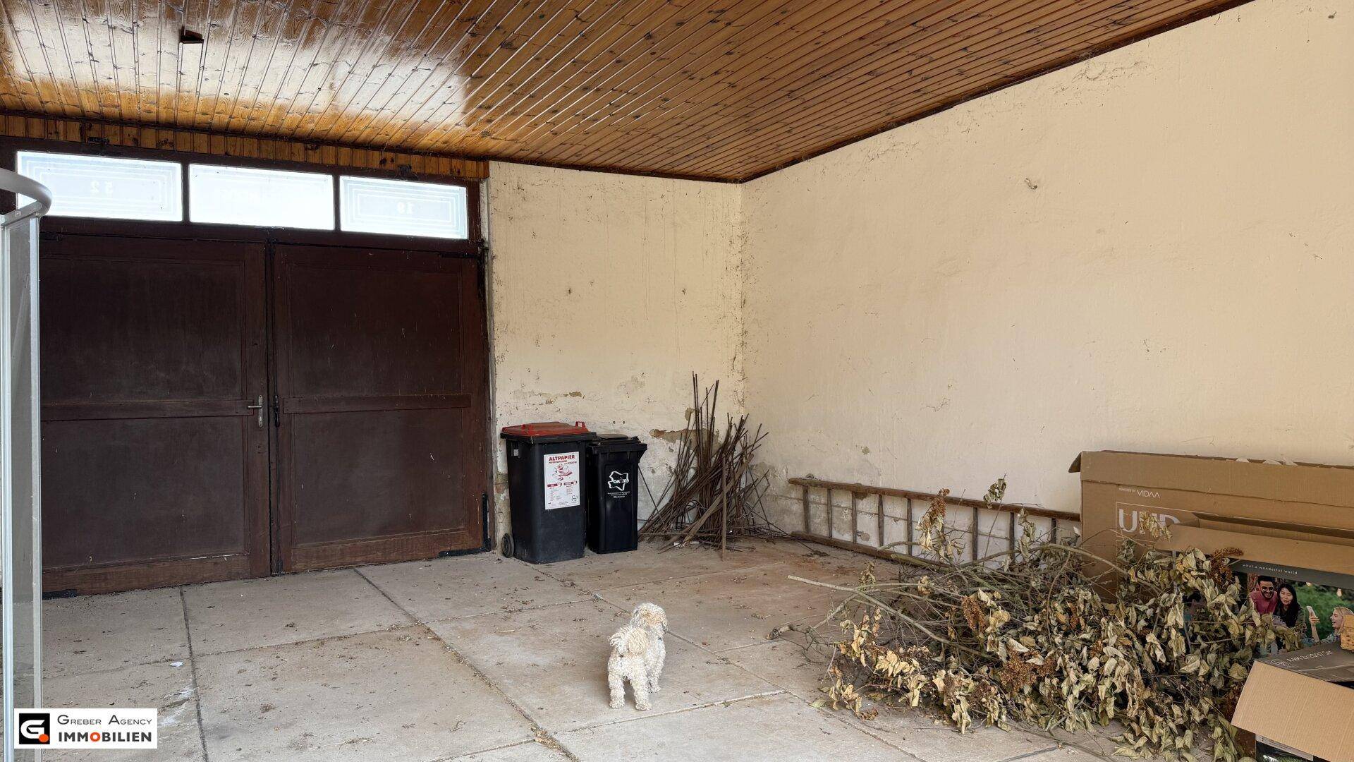 Innenansicht einer Garage oder eines Abstellraums mit Holztäfelung an der Decke.