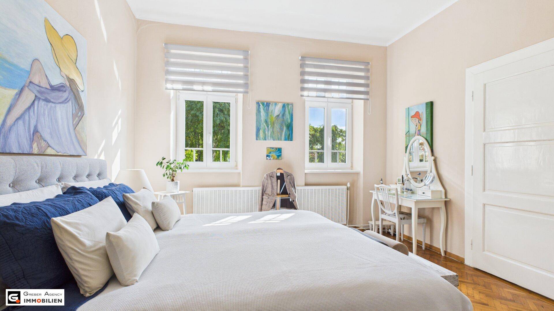 Gemütliches Schlafzimmer mit Doppelbett, Schminktisch und Blick ins Grüne.