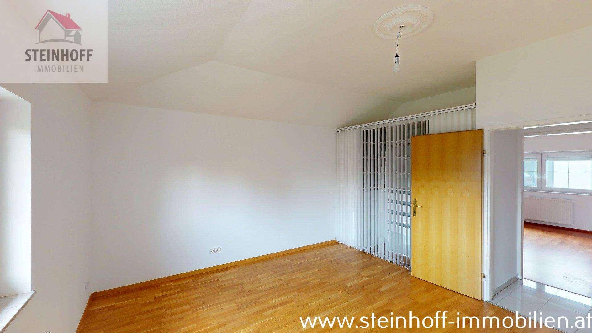 Leerer Raum mit Holzboden und Fenster, bietet vielseitige Nutzungsmöglichkeiten für Bewohner.