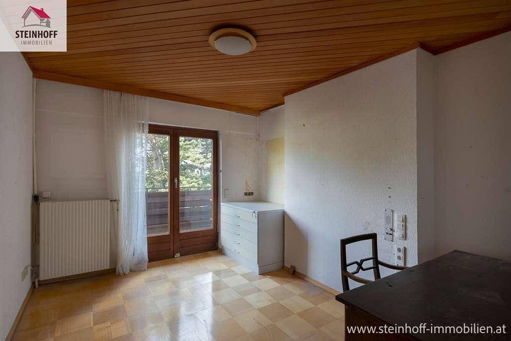 Schlafzimmer mit Parkettboden, Holzdecke und Zugang zu einem Balkon.