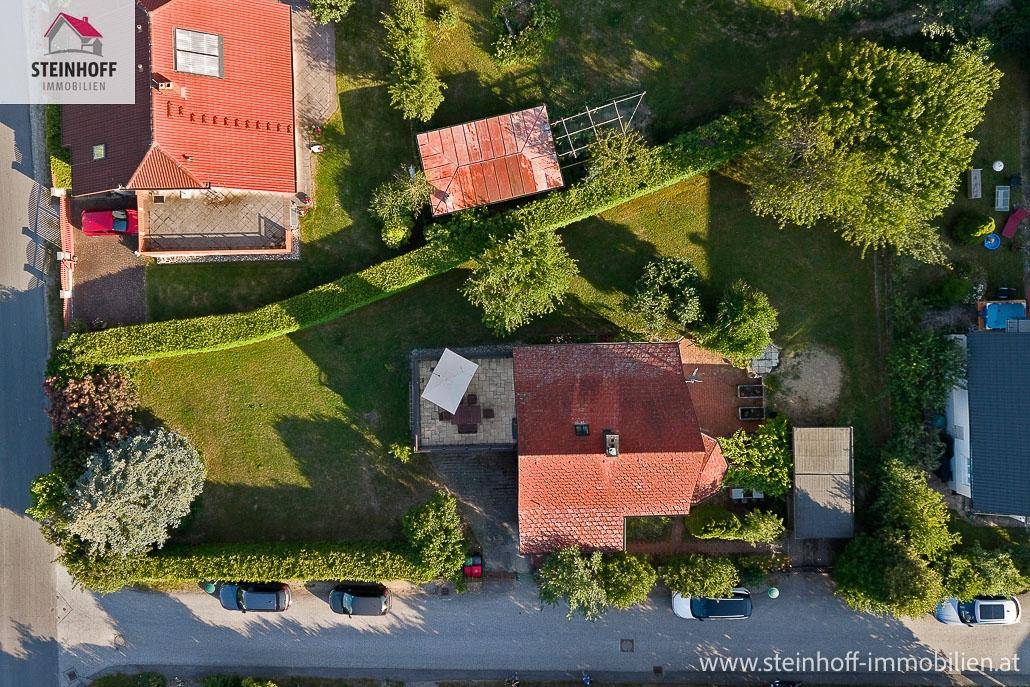 Luftaufnahme des Grundstücks mit Haus, Garten und umliegender Bebauung.