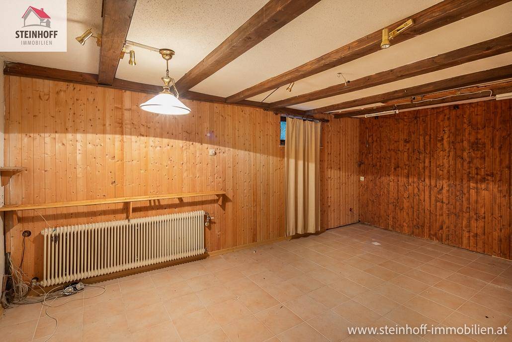 Rustikaler Raum mit Holzvertäfelung an Wänden und Decke sowie Fliesenboden, ideal als Hobbyraum.