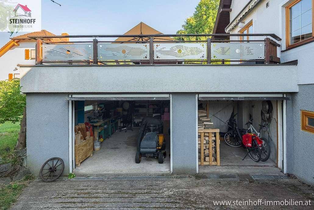 Doppelgarage unterhalb der Terrasse mit Stauraum und Werkstattbereich.