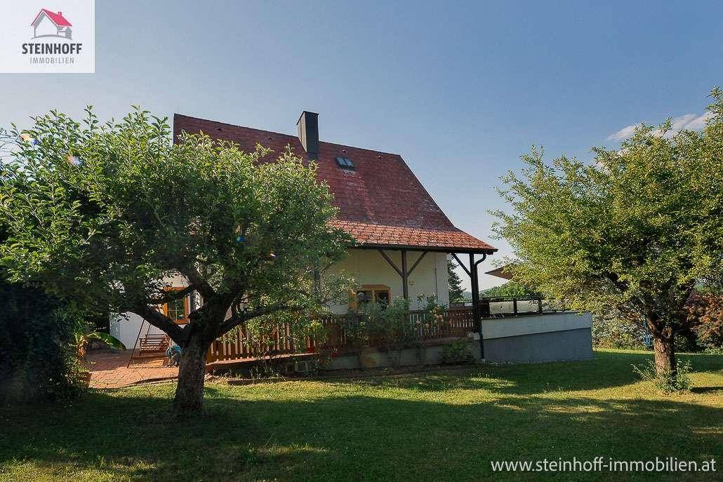 Gartenbereich mit Rasen, Obstbäumen und Blick auf das Einfamilienhaus mit Terrasse.