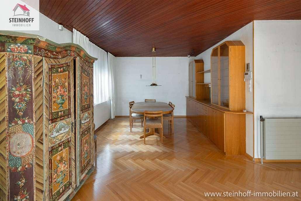 Geräumiges Esszimmer mit Fischgrätparkett, Holztäfelung an der Decke und traditionellen Möbeln.