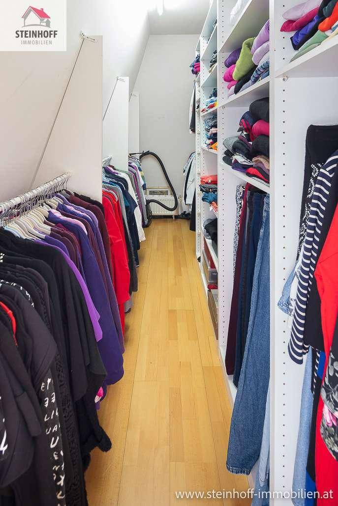 Begehbarer Kleiderschrank mit vielen Regalen und Kleiderstangen für optimale Organisation.